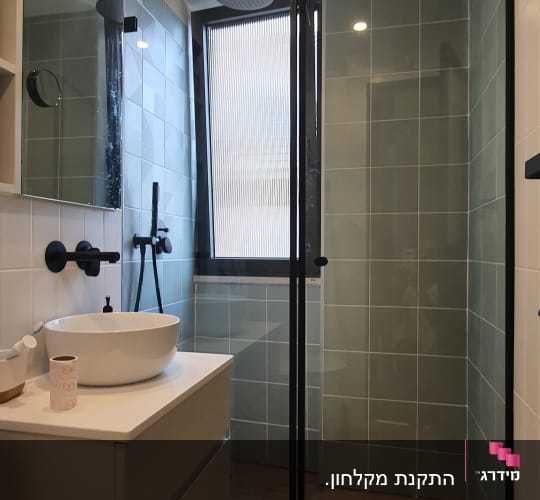 מקלחת עם דלת זכוכית, ראש מקלחת עגול, אריחים ירוקים